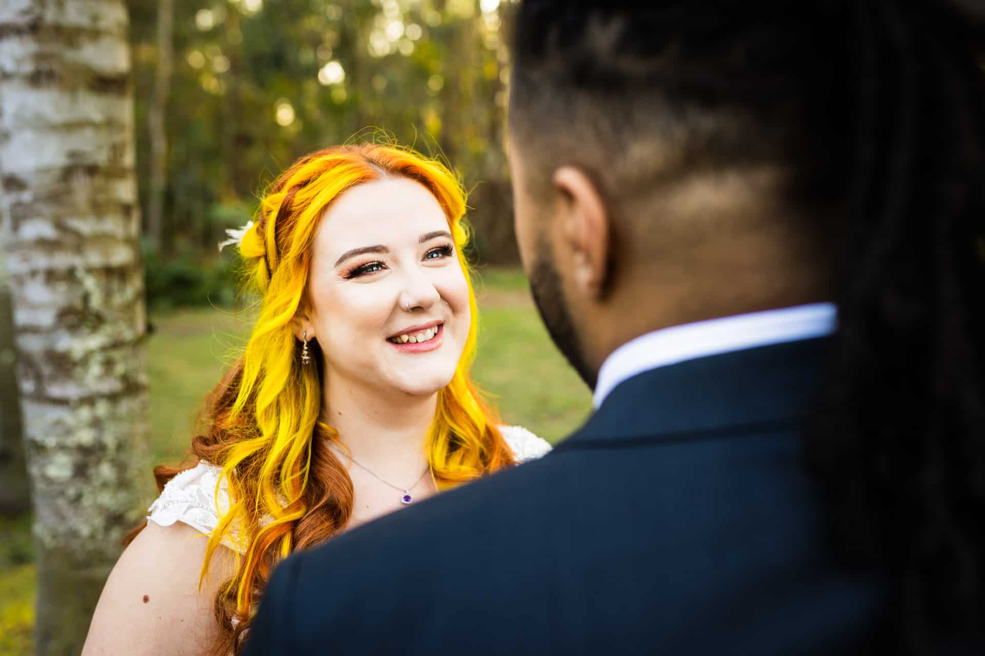 Bride smiles as she looks at her groom during the first look.