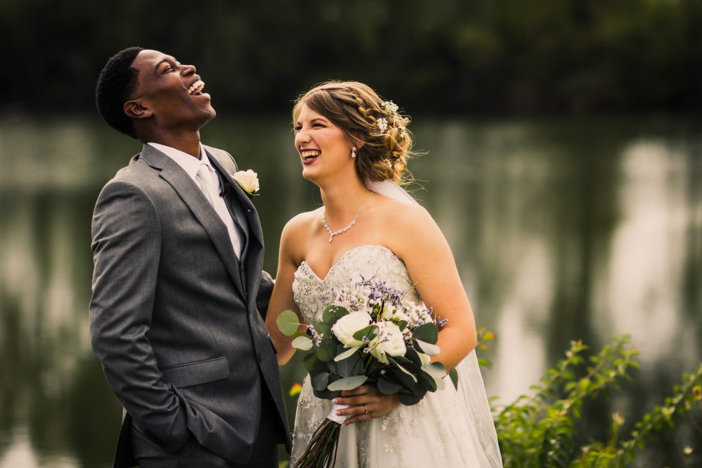 A bi-racial couple have a moment of laughter during their wedding day.